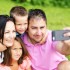 family taking selfies with smartphone in park